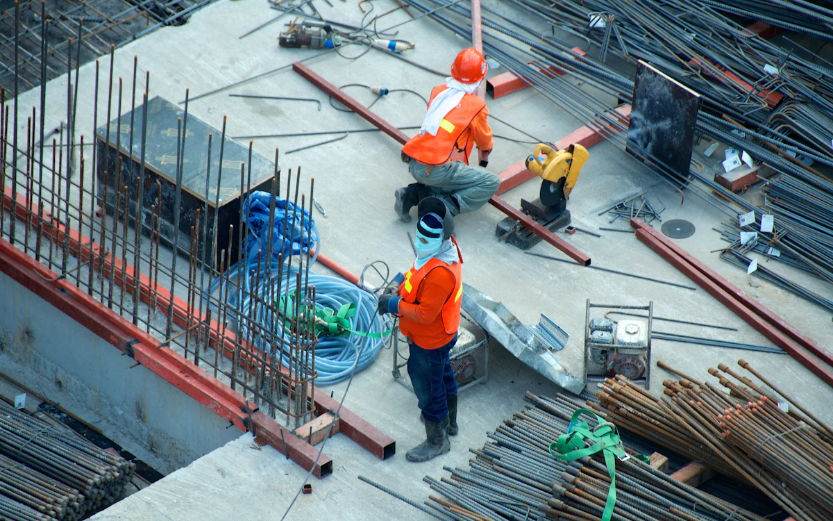 Construction workers managing active building site records and project work